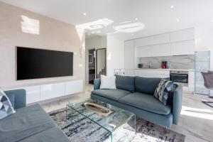 un salon avec un canapé bleu et une télévision dans l'établissement Kuca Nena, à Crikvenica