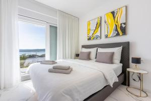 une chambre avec un grand lit avec une grande fenêtre dans l'établissement Kuca Nena, à Crikvenica 55 autres photos