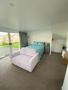 a bedroom with a bed and a couch at Birch Court - Tui in Whanganui