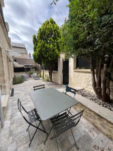 a table and chairs sitting on a patio at Le Capella, magnifique maison au calme avec garage in Caen