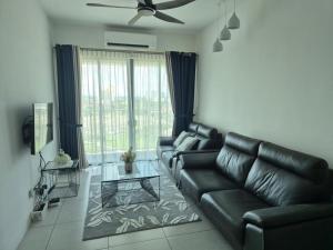 a living room with a black leather couch and a table at Meritus - Perai in Perai