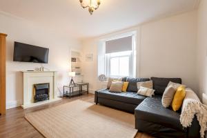 a living room with a couch and a fireplace at Kinness Place - No 6 in St. Andrews