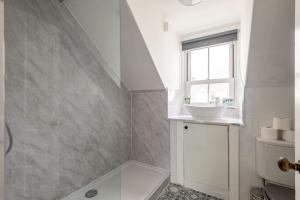 a white bathroom with a sink and a window at Kinness Place - No 6 in St. Andrews +17 photos