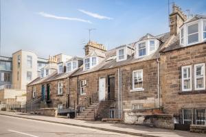 an old brick building with stairs on a street at Kinness Place - No 6 in St. Andrews