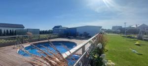 a backyard with a swimming pool and a fence at RESET domki letniskowe in Gąski
