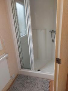 a shower with a glass door in a bathroom at Haven Devon Cliffs Caravan in Budleigh Salterton +19 photos