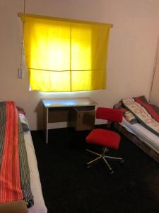 a bedroom with a desk and a red chair at Penni panzió Kaposvár- répáspuszta in Kaposvár +8 photos