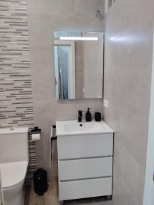 Un baño con un lavabo blanco y un inodoro. en Apartamento Plaza Palmeras2, en Burjasot 7 fotos más