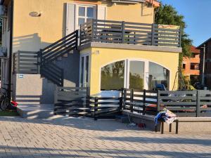 a house with a large deck on top of it at Apartman Lana in Klimno