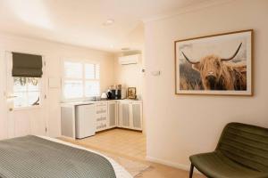a bedroom with a picture of a cow on the wall at Peony Farm Green Cottage in Stanley