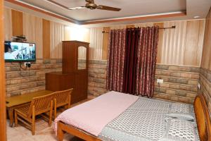 a bedroom with a bed and a desk and a television at Hotel Sunrise in Chandīgarh