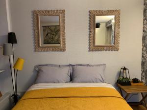 una camera da letto con due specchi a parete e un letto di Duplex La Maisonnette 1 chambre - parking gratuit a Troyes