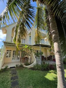 a white house with a palm tree in front of it at 3bedroom house, pool & garden! in Calodyne +18 photos