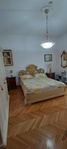 a bedroom with a large bed and a wooden floor at Casa Vacanza a Limbiate in Limbiate