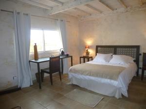 a bedroom with a bed and a desk and a window at La Casa Nert in Millas
