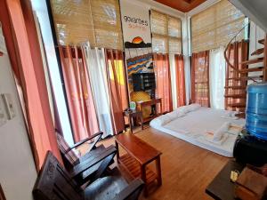 a living room with a bed and some windows at The Bistro House - Govantes Guesthouse in San Vincente