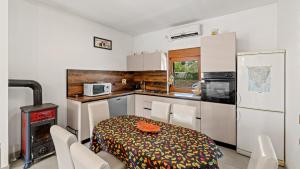 una cucina con tavolo e sedie e una cucina con piano cottura di Villa Zivolic by Villas Holiday a Bičići
