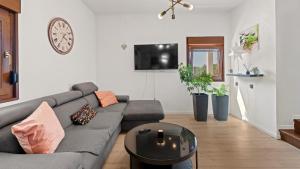 un soggiorno con un divano grigio e un tavolo di Villa Zivolic by Villas Holiday a Bičići