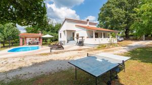 una casa con piscina e tavolo nel cortile di Villa Zivolic by Villas Holiday a Bičići