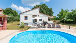una villa con piscina di fronte a una casa di Villa Zivolic by Villas Holiday a Bičići