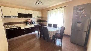 a kitchen with a table and chairs and a refrigerator at Cabana Lazea in Gîrda de Sus