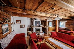 a living room with red chairs and a fireplace at Resort Vysoká Lípa in Jetřichovice