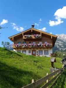 a house on a hill with flowers on it at Onemooshof in Maria Alm am Steinernen Meer