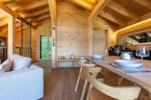 a wooden cabin with a long wooden table and chairs at Base Camp COSY chalet 4 personnes in Les Mosses