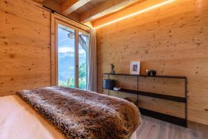 a bedroom with a bed with a large window at Base Camp COSY chalet 4 personnes in Les Mosses