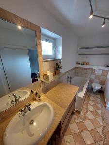 a bathroom with a sink and a tub and a toilet at City Oasis Salzburg in Salzburg +35 photos