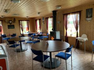 a dining room with tables and blue chairs at Camping Fredrika-Braber in Fredrika