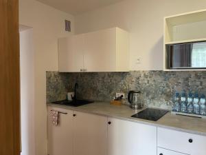 a kitchen with white cabinets and a counter top at Apartamenty AGAT in Pieszyce