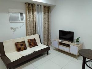 a living room with a couch and a tv at Jojies Crib Horizons101 Studio in Cebu City