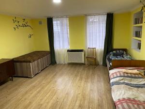 泰拉维hostel Ajime的一间卧室设有黄色的墙壁和木地板。