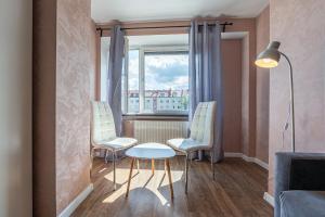 Una habitación con dos sillas y una mesa y una ventana. en Grand Solen Apartment, en Gdansk
