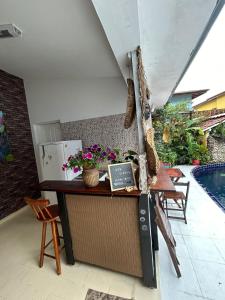 Un restaurante con un mostrador con flores y una piscina. en Mama House, en Ubatuba