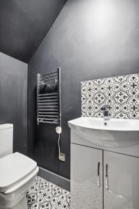 ロンドンにあるCozy London Apartmentの白い洗面台とトイレのあるバスルーム