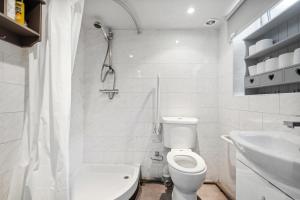 ロンドンにあるCozy London Apartmentのトイレと洗面台を備えた白いバスルーム