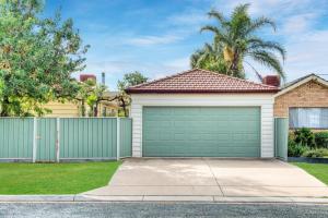 a house with a green garage at Ayr House - Echuca Holiday Homes in Echuca