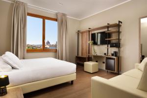 una camera d'albergo con un letto e un divano di Essence Hotel a Firenze