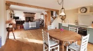 eine Küche und ein Wohnzimmer mit einem Holztisch und Stühlen in der Unterkunft Rocking Stone Cottage in Matlock