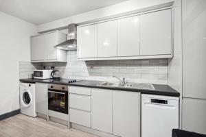 ロンドンにあるCozy London Apartmentの白いキッチン(白いキャビネット、シンク付) +4枚の写真
