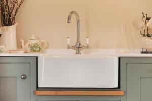 eine Küchenspüle mit einem Wasserhahn auf der Theke in der Unterkunft Rocking Stone Cottage in Matlock + 37 Fotos