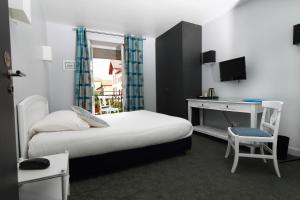 - une chambre avec un lit et un bureau avec un ordinateur dans l'établissement Hôtel Ohartzia, à Saint-Jean-de-Luz