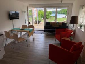 a living room with a couch and a table and chairs at Forsthaus am See Lychen in Lychen