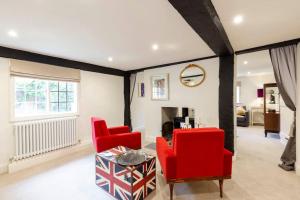 a living room with red chairs and a table at Dorney Windsor Legoland 5 Star Stay for upto 14 guests in Dorney