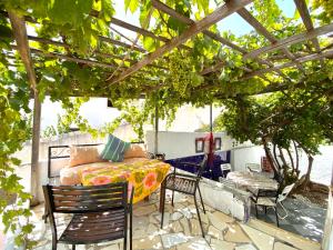 a patio with a bed and chairs under a pergola at Dua hostel in Tetouan