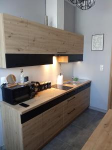 a kitchen with a counter with a sink and a microwave at Noclegi 24h Przemyśl in Przemyśl +12 photos
