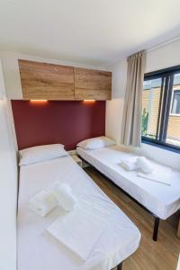 a room with two beds and a window at I Campi Wine Relais Mobile Homes in Ronchi +34 photos