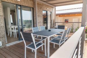 a patio with a table and chairs on a deck at I Campi Wine Relais Mobile Homes in Ronchi